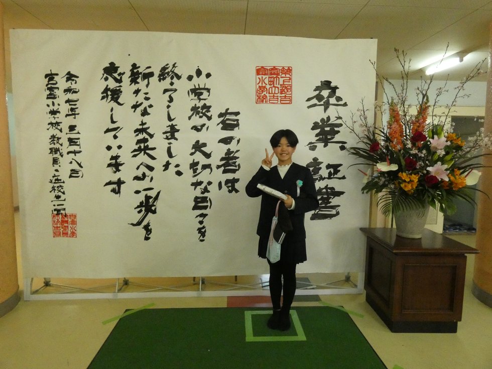 巨大卒業証書で写真撮影する様子
