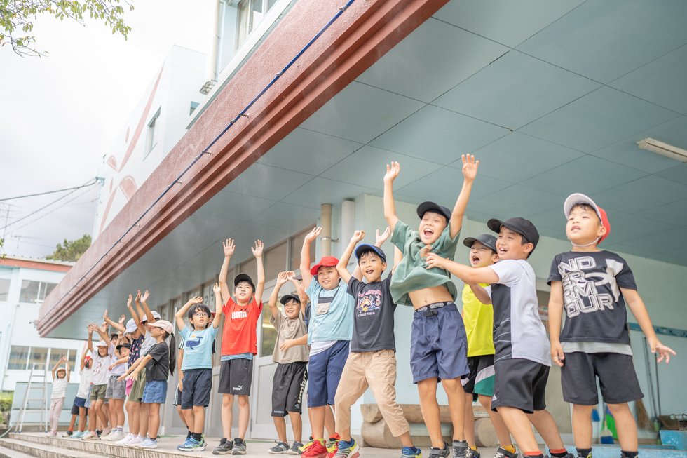 吉富小学校でミストシャワーを浴びる児童たち