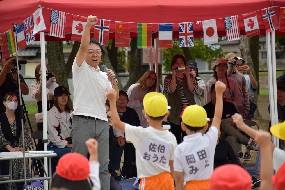 園児と掛け声を上げる町長