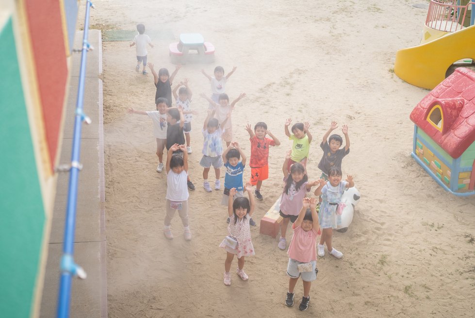 こどもの森でミストシャワーを浴びる園児たち