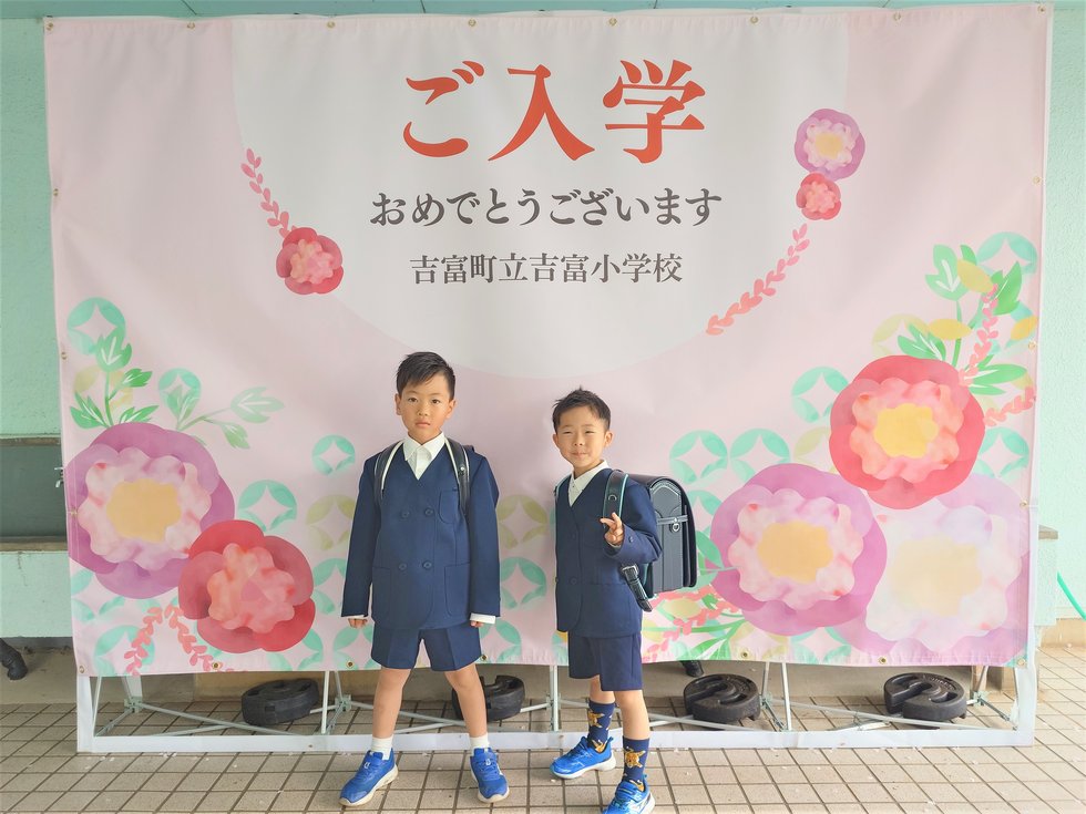 入学幕フォトスポットで友達と記念写真を撮っている様子です。